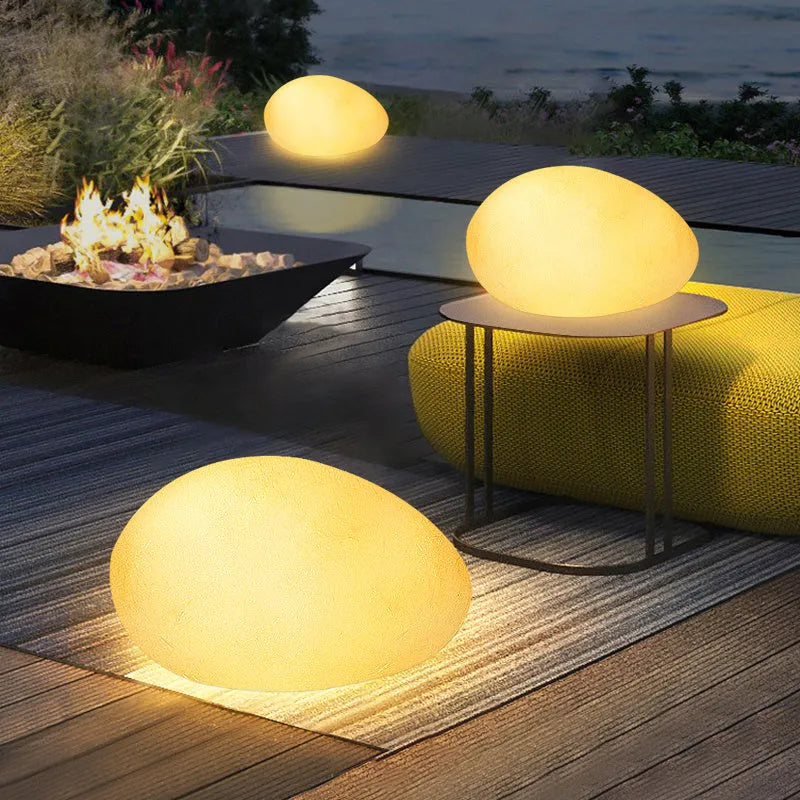 Outdoor pebble light in stone shape with IP65 waterproof rating, available in 26-48cm sizes for garden path, solar or rechargeable power options