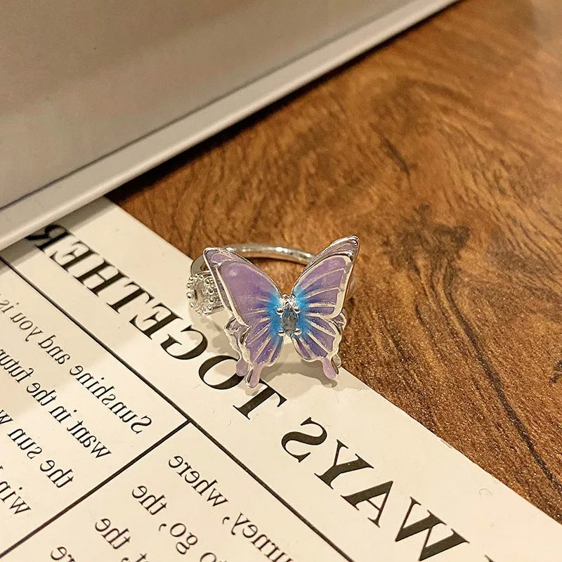 Antiqued copper butterfly women's ring showing the oil-drip patina finish on a simple band.