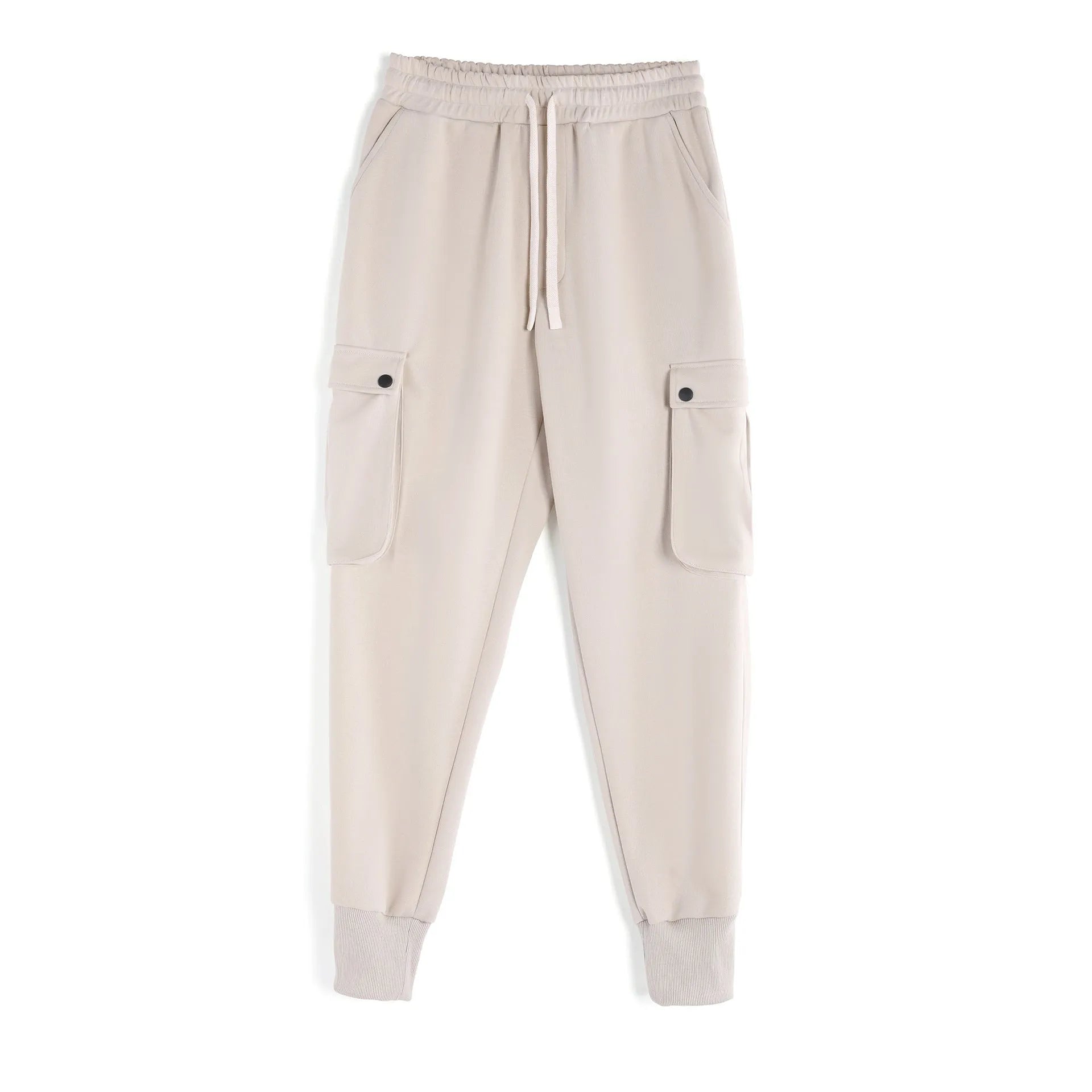 Man wearing loose light grey cotton sports trousers with ankle ties and multiple pockets.