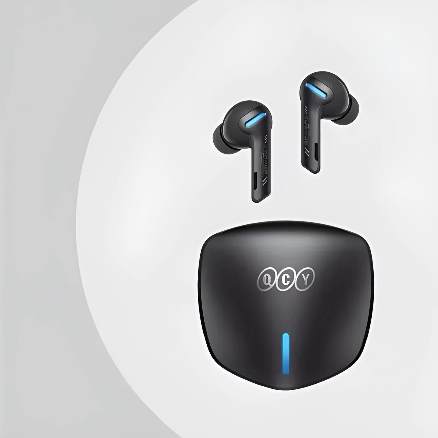 Grey QCY-G1 wireless Bluetooth gaming headset with charging case and ear tips on a table.