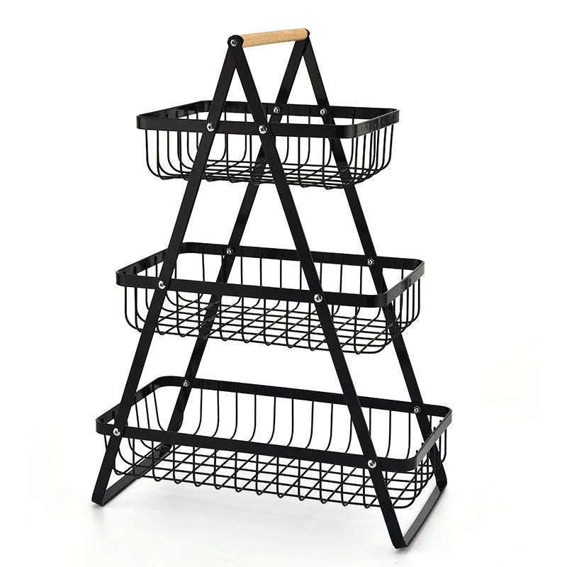 Black detachable iron double-layer fruit basket with a wooden handle on a kitchen counter.