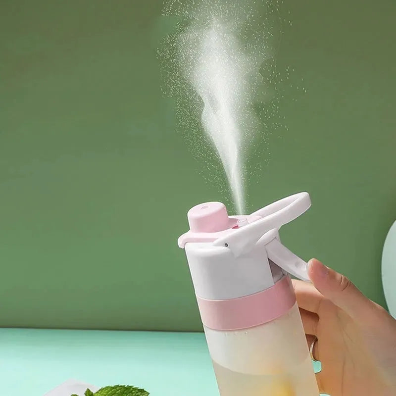 Large pink plastic spray water bottle with a handle strap and leakproof lid on a gym bag.
