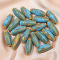 Ten ceramic bullet beads with a glazed finish arranged together, showing assorted colour options.