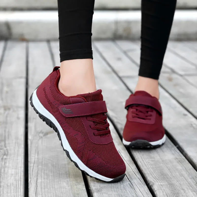 Women's low-top casual sneaker with mesh upper, wedge heel, and Velcro strap fastening.