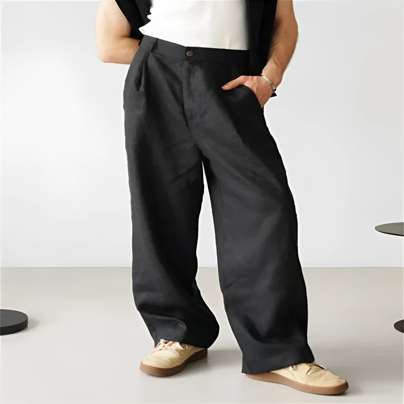 Men's loose linen high-waist jogger trousers in grey showing pleated detail and straight-leg fit