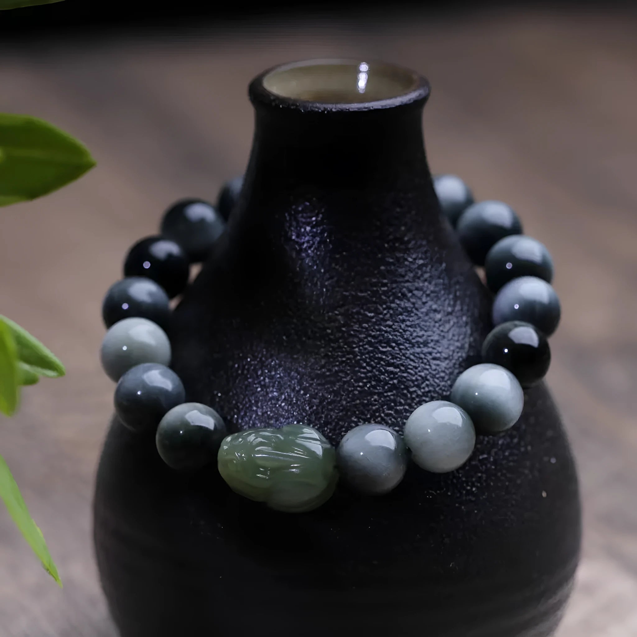 10mm Eagle Eye Stone bead bracelet with a natural Hetian Jade Clear Water Pixiu charm on a black cord.