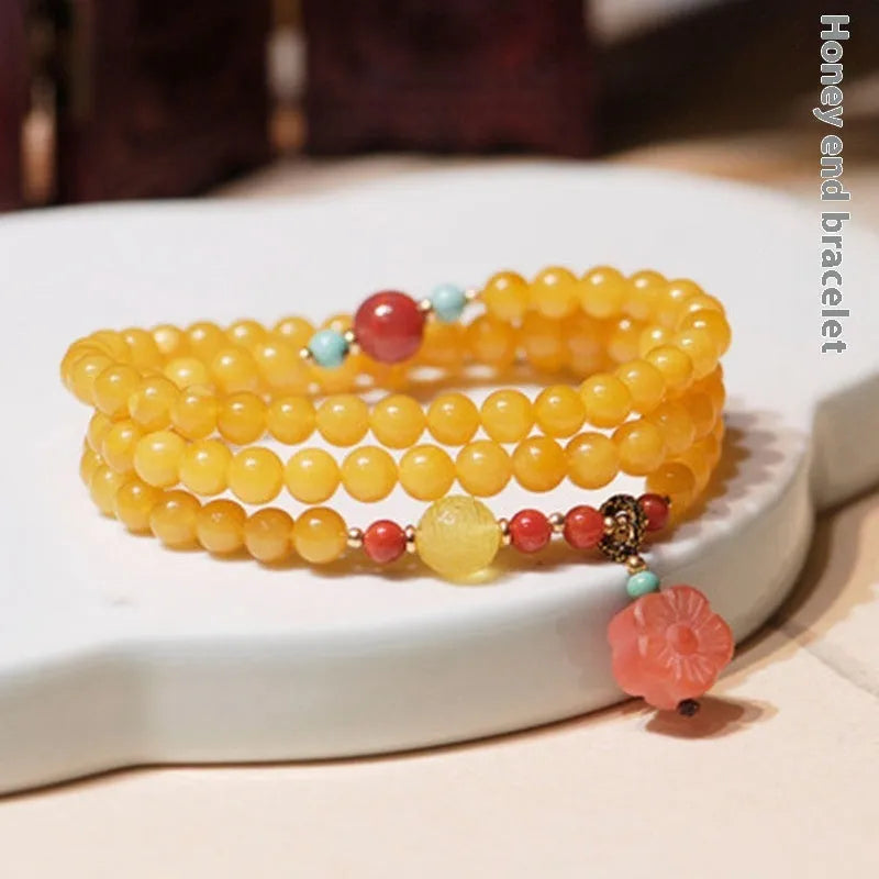 Yellow amber bracelet with 5mm round beads and an animal zodiac charm on a white background.