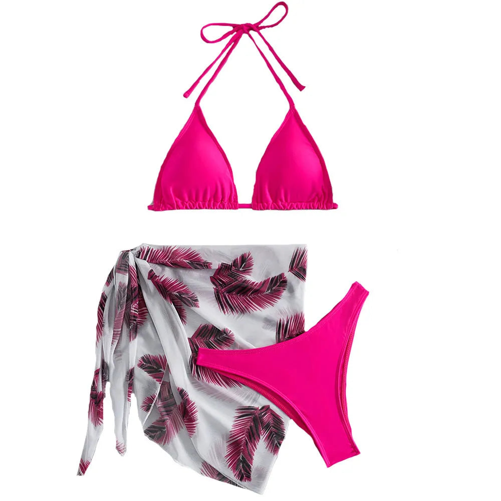 Women's orange three-piece bikini swimsuit set with a matching printed gauze skirt laid flat.