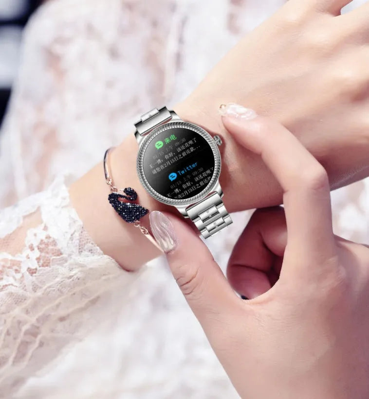 AK38 ladies smart watch with stainless steel Milanese band showing on a wrist.