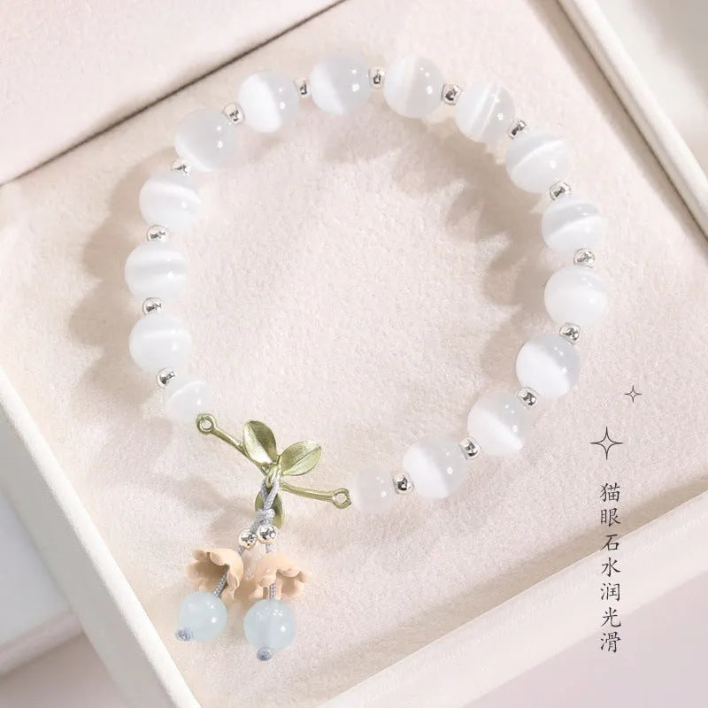 Women's beaded bracelet with diamond-shaped cat's eye opal stones in multiple colour options on a wrist.