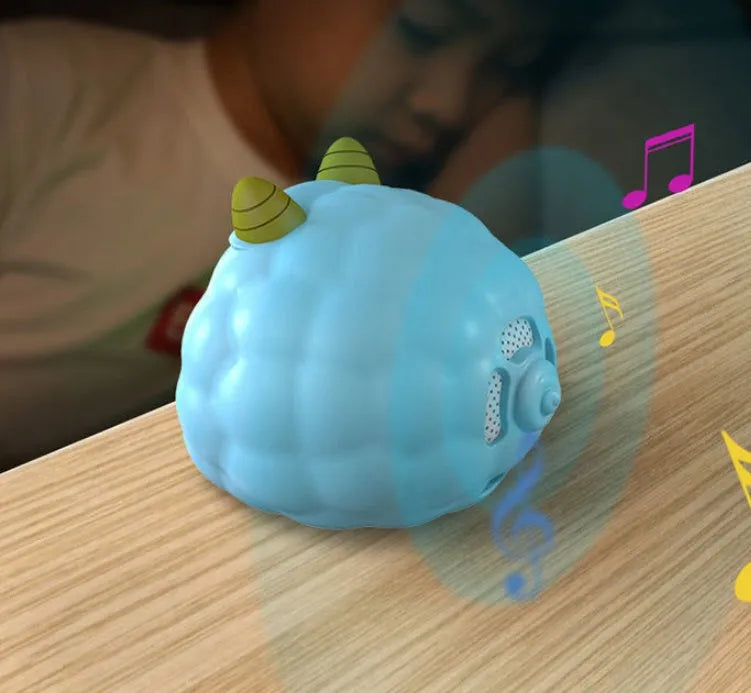 Silicone smart alarm clock with voice control, human body sensor, and luminous display on a bedside table.