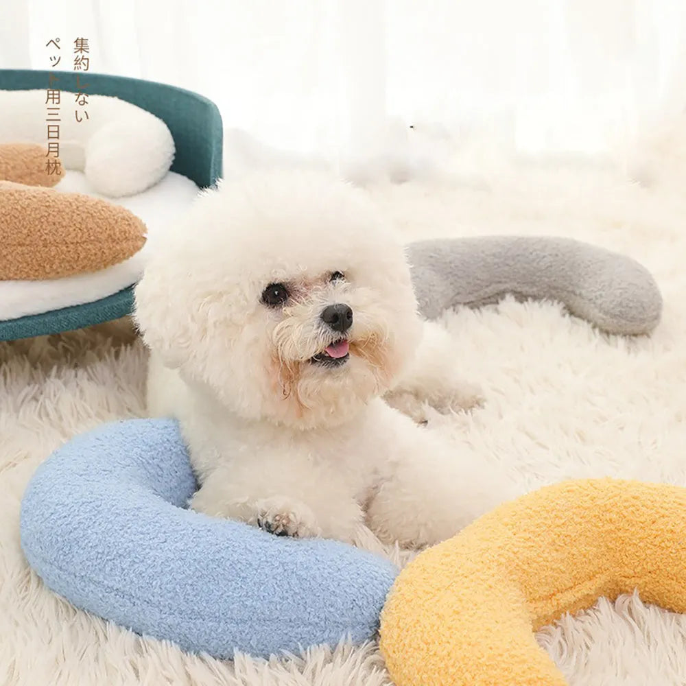 Blue U-shaped cat pillow with an adjustable fabric collar resting on a grey blanket.