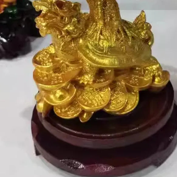 Citrine-coloured resin Feng Shui ornament of a small turtle on a money tree.