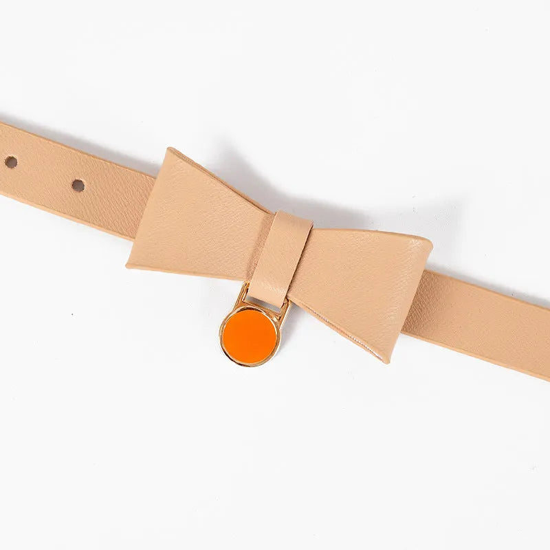 Brown leather cat collar with silver buckle shown adjusted on a table.
