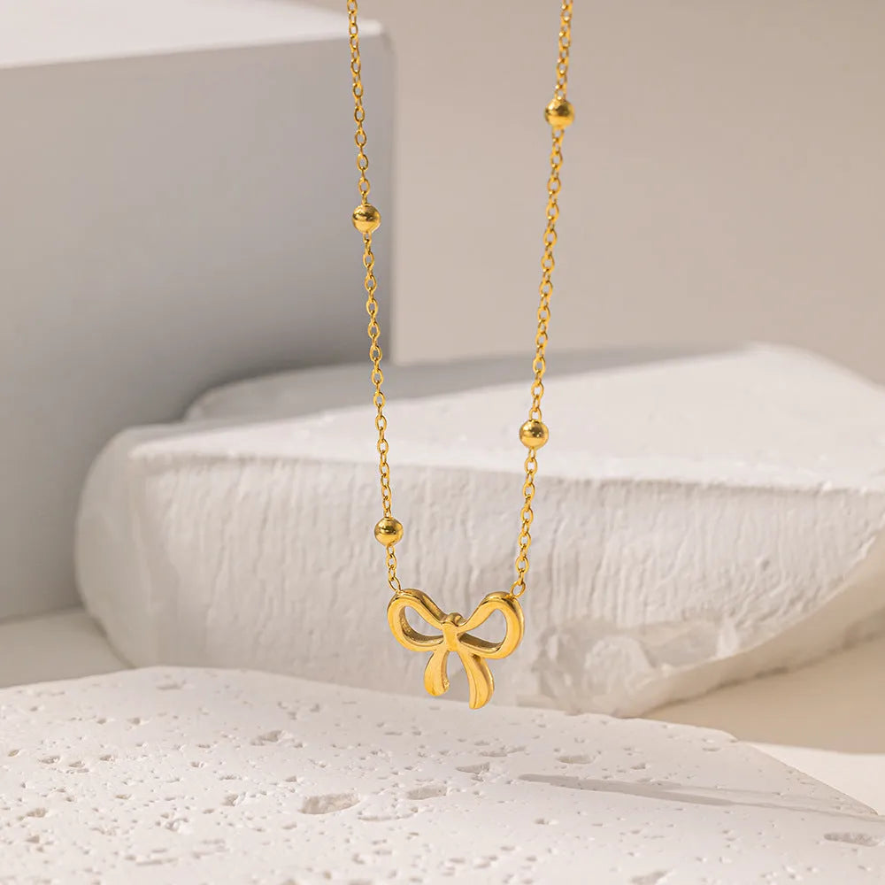 Gold titanium steel bow necklace for women with adjustable length and cross chain design