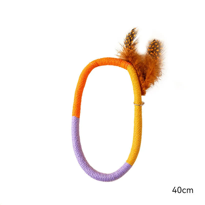 Green circular cotton rope cat toy with feathers and catnip for chewing and interactive play.