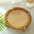 Brown woven rattan raised cot bed for cats and small dogs on a wooden floor