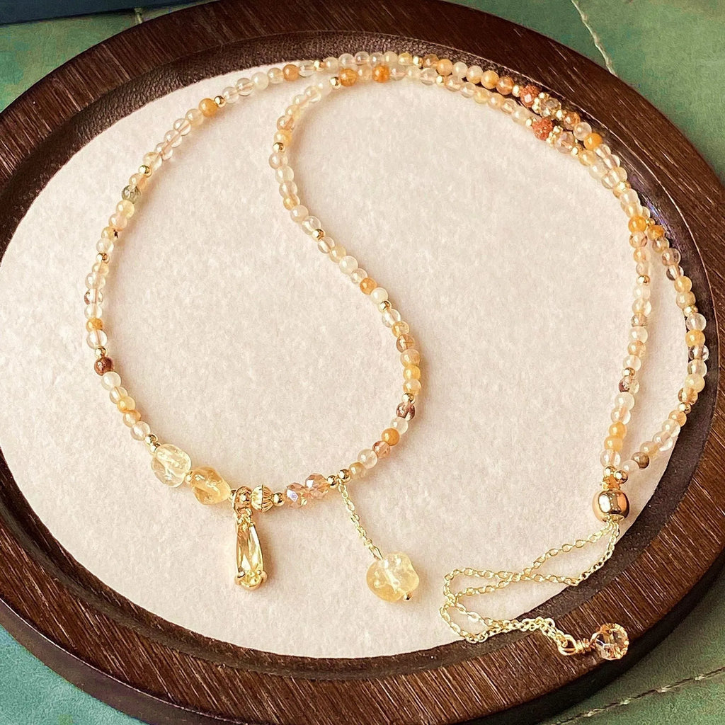 Gold electroplated bracelet with three circles of caramel citrine and a Saturn charm.