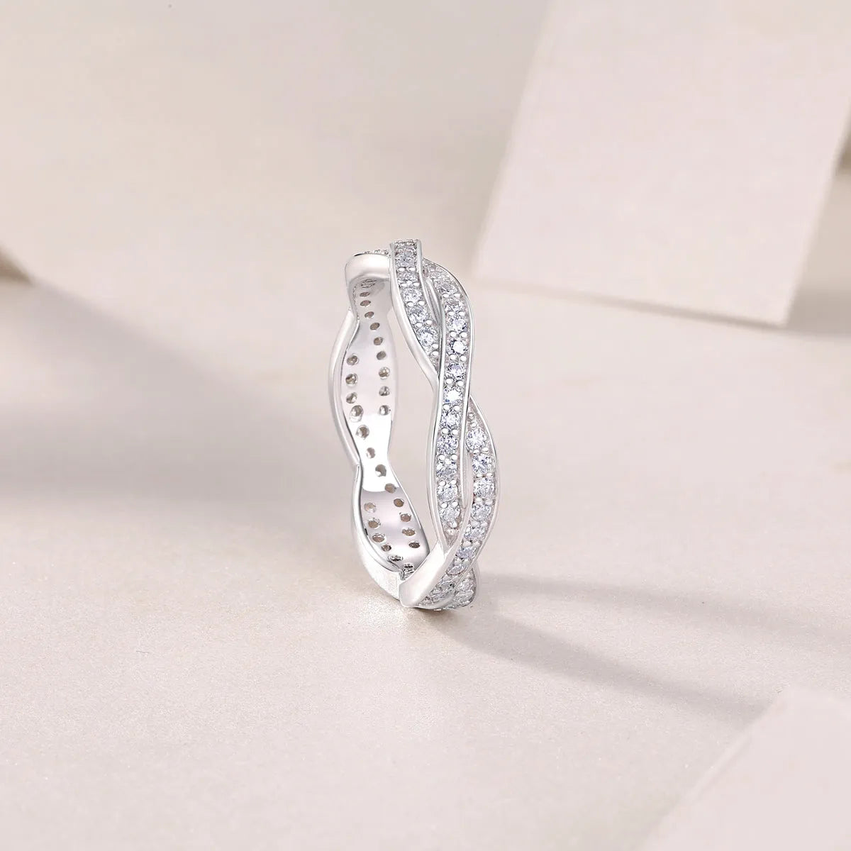 Moissanite wedding ring set in S925 silver with platinum plating on a white background
