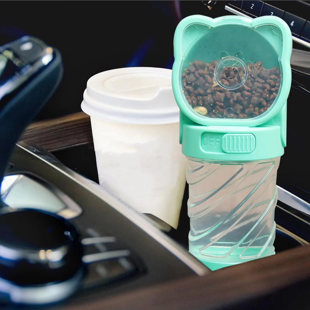 Green 3-in-1 portable pet water bottle with food container and waste bag dispenser, held by its strap.