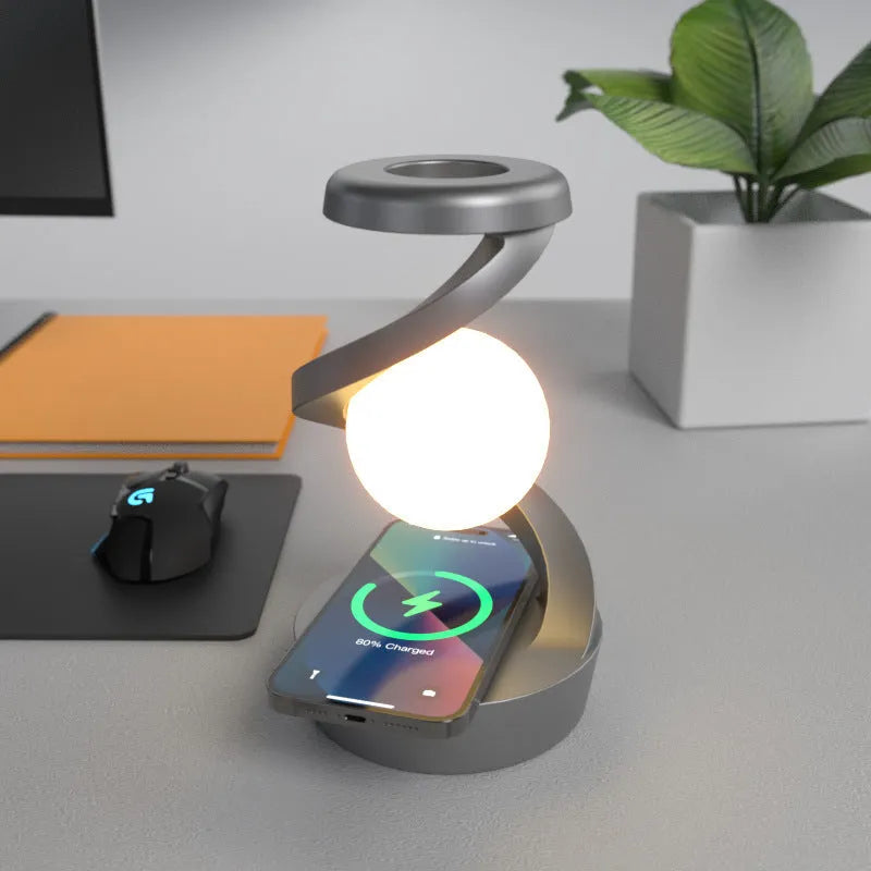 Rotating moon desk lamp with wireless charger in grey on a bedside table