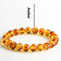 Natural yellow piebald amber geometric bracelet on a wrist, showing polished beads with flower spot patterning.