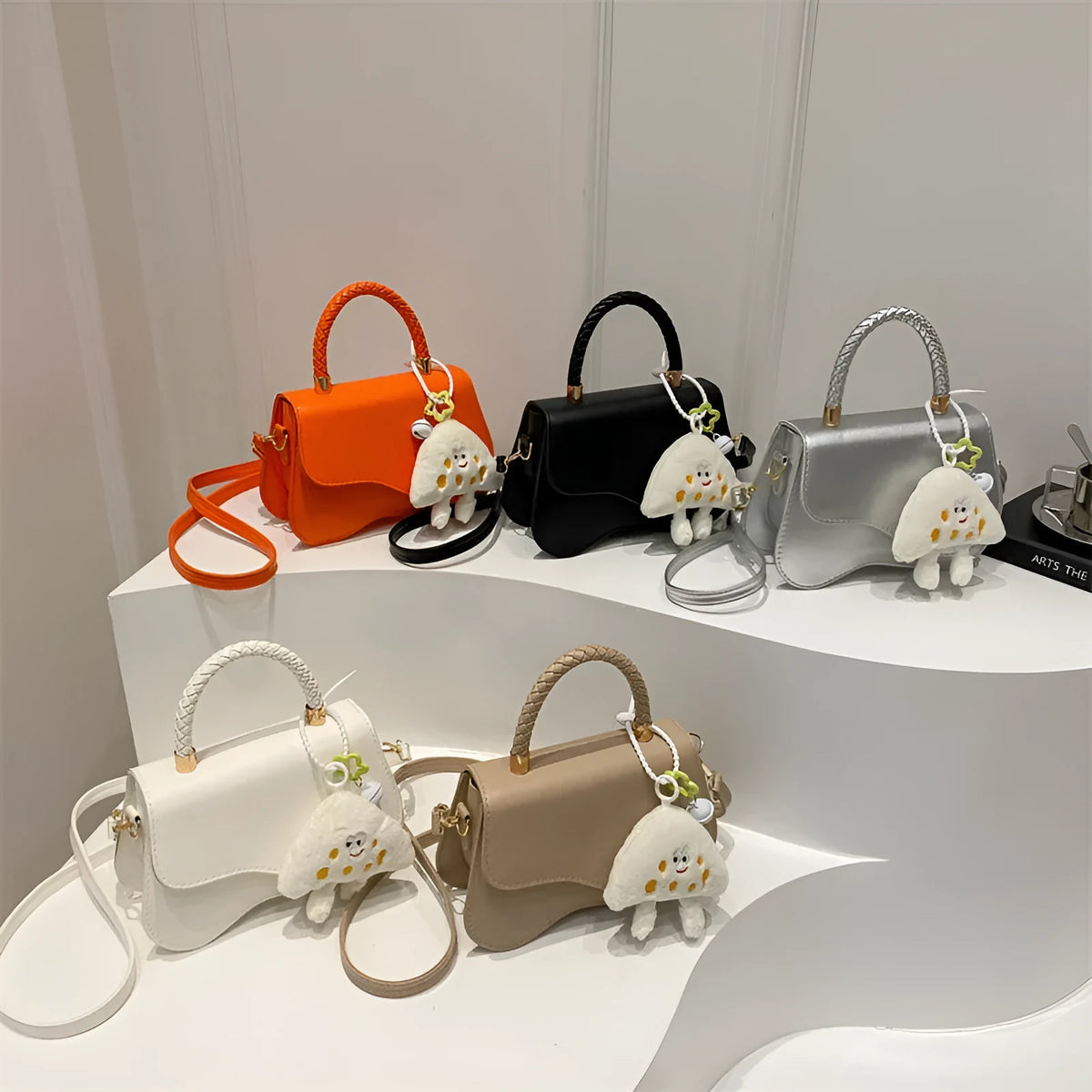 Soft PU one-shoulder bag with magnetic snap, horizontal square shape, shown in khaki with optional pendant.