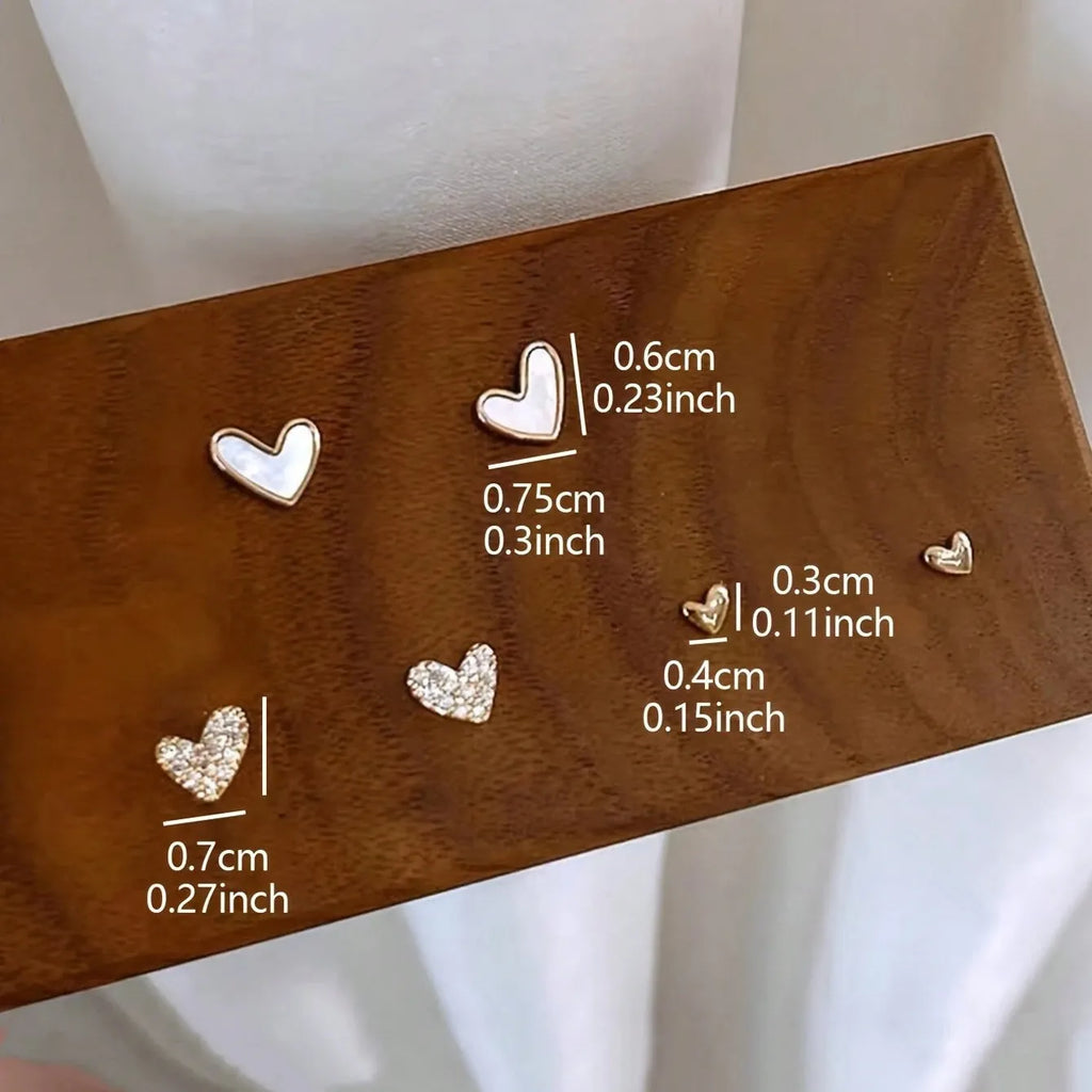 Three pairs of heart-shaped alloy earrings with electroplated finish in gold, black, pink or black and white
