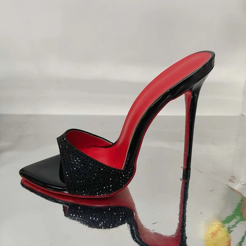 Black rhinestone ankle-strap open toe sandal with super high heel and pointed toe on white background
