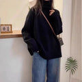 Women's loose grey turtleneck sweater with a textured curling collar and 3D pattern detail.