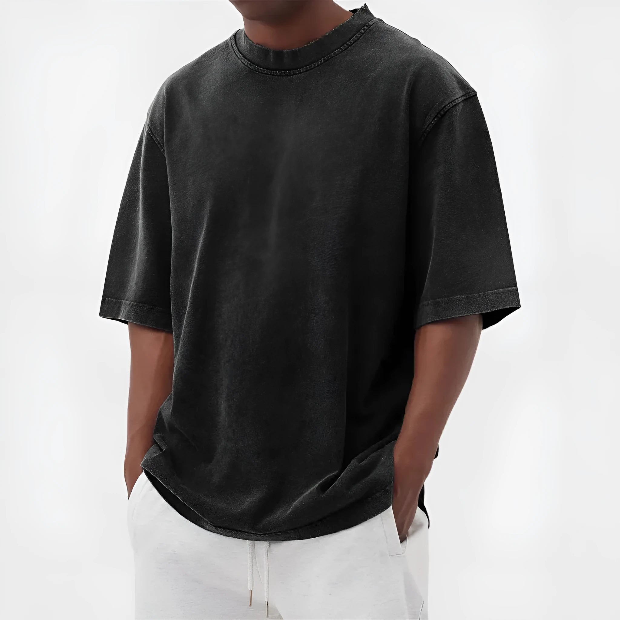 Man wearing a loose fit stone washed distressed t-shirt in a solid colour, showing short sleeves and casual styling.