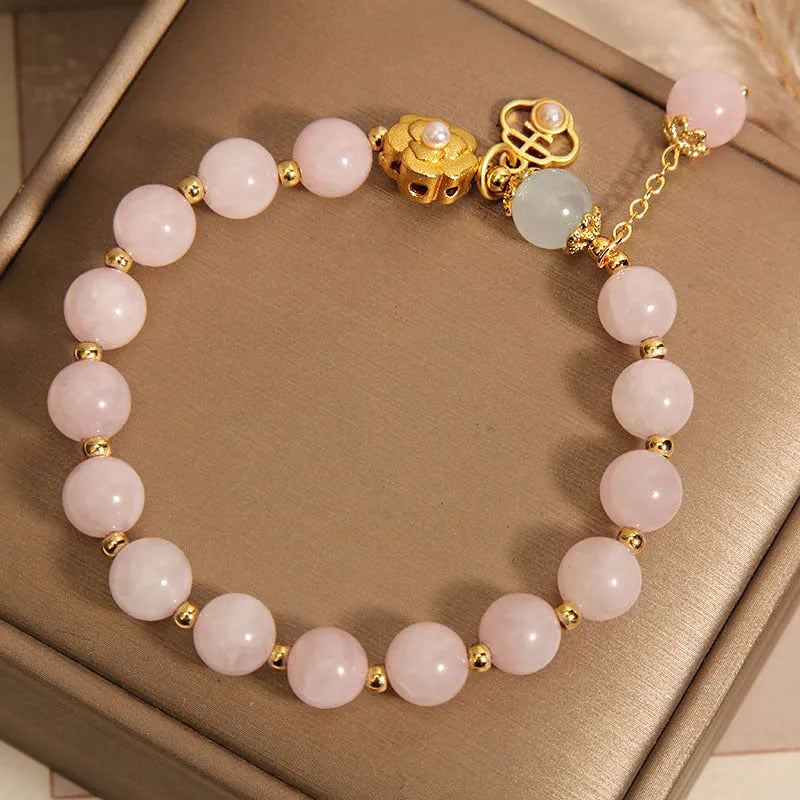 Close-up of a women's pink crystal flower bracelet on an adjustable chain.