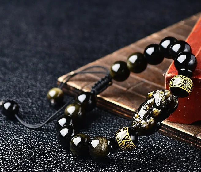 Original hand-woven golden obsidian Pi Xiu bracelet showing bead detail and Chinese style design