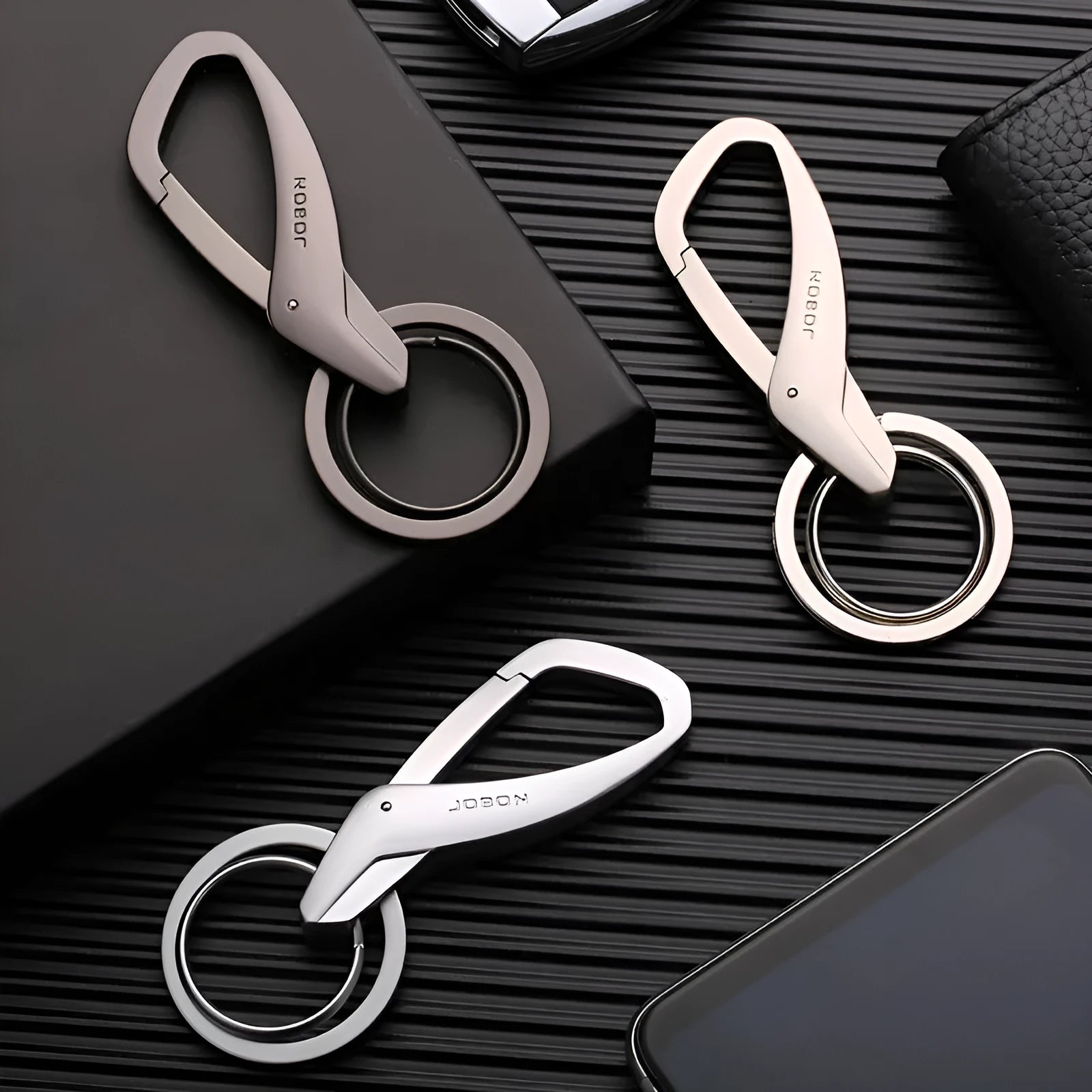 Zinc alloy double ring keychain in black, chrome, or nickel colour, shown with dimensions 8.3 by 3.5 cm.