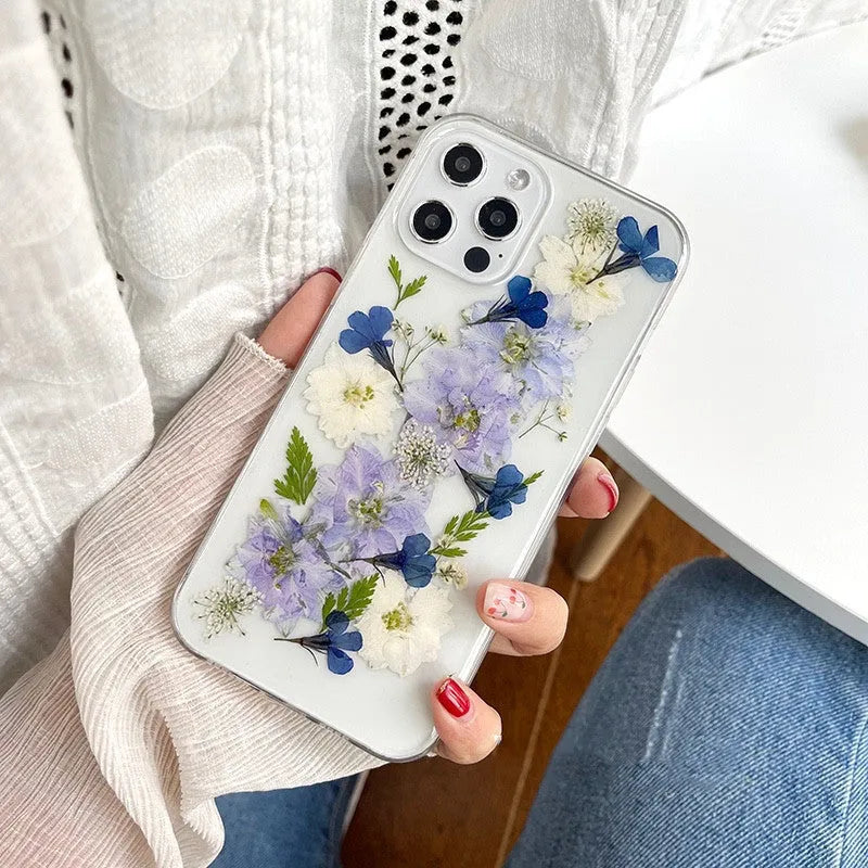 Soft blue and purple dried floral bouquet design on a transparent TPU case for an iPhone.