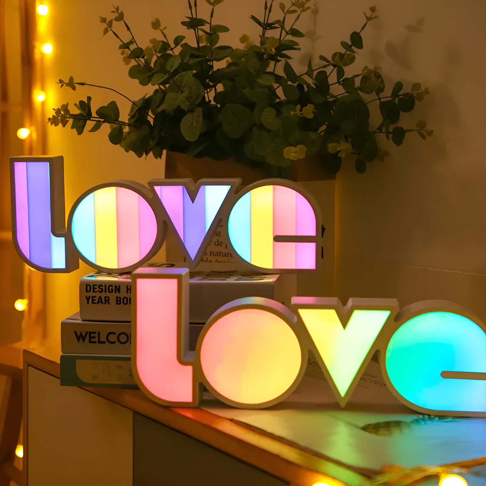 Rainbow coloured plastic LED LOVE light decoration on a desk.