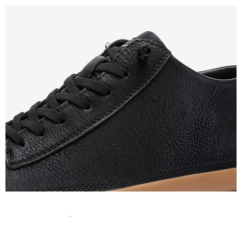 Men's black leather casual shoes with round toe and white flat rubber sole on a plain background