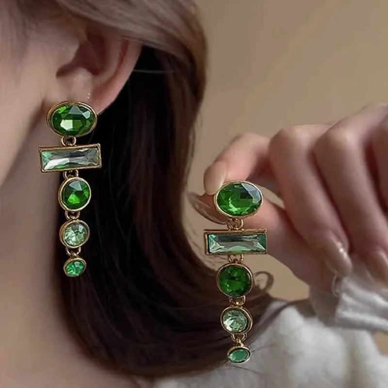A pair of retro green gradient alloy earrings with geometric Chinese-style design, inlaid zircon stones, and decorative tassels.