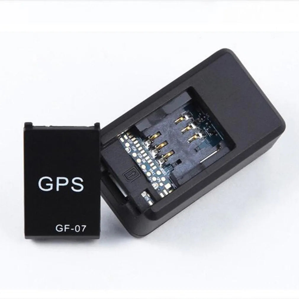 Small black magnetic GPS tracker device next to a USB charging cable.