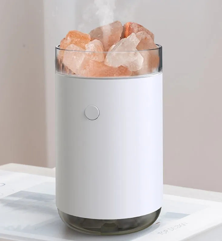 White desktop ultrasonic humidifier with crystal salt stone and LED lamp showing side view on table