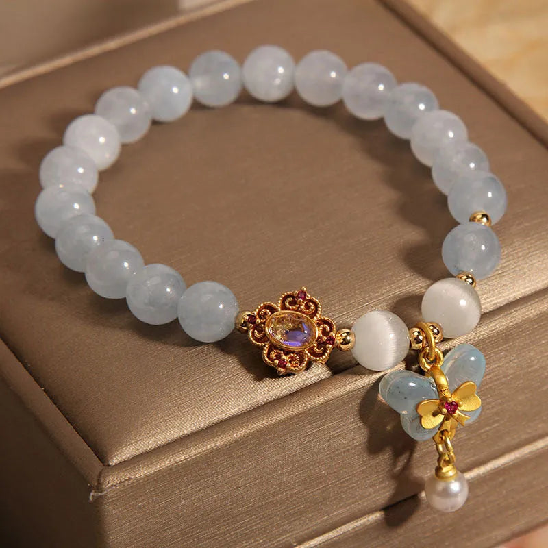 Aquamarine crystal butterfly pendant bracelet for women with rhinestone accents on a white background.