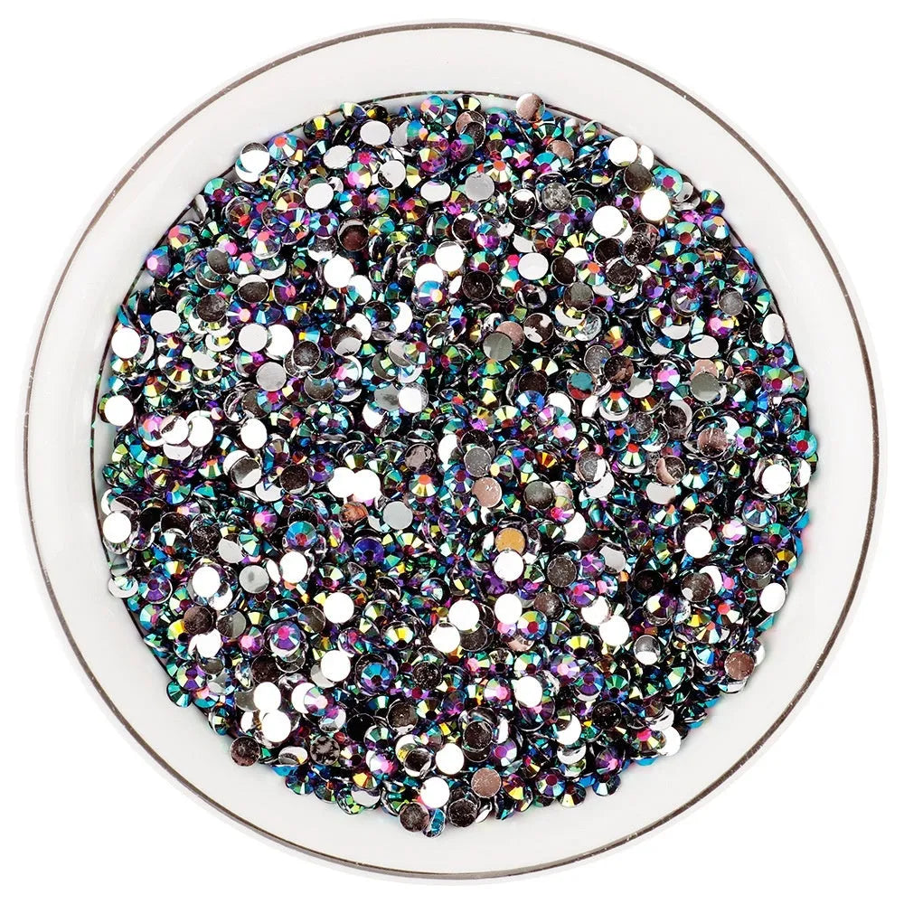 Assortment of multicoloured flat back resin rhinestones in various sizes for nail art and craft projects.