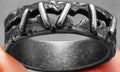 Stainless steel double band ring with dark punk stitching details on a size 10 finger.