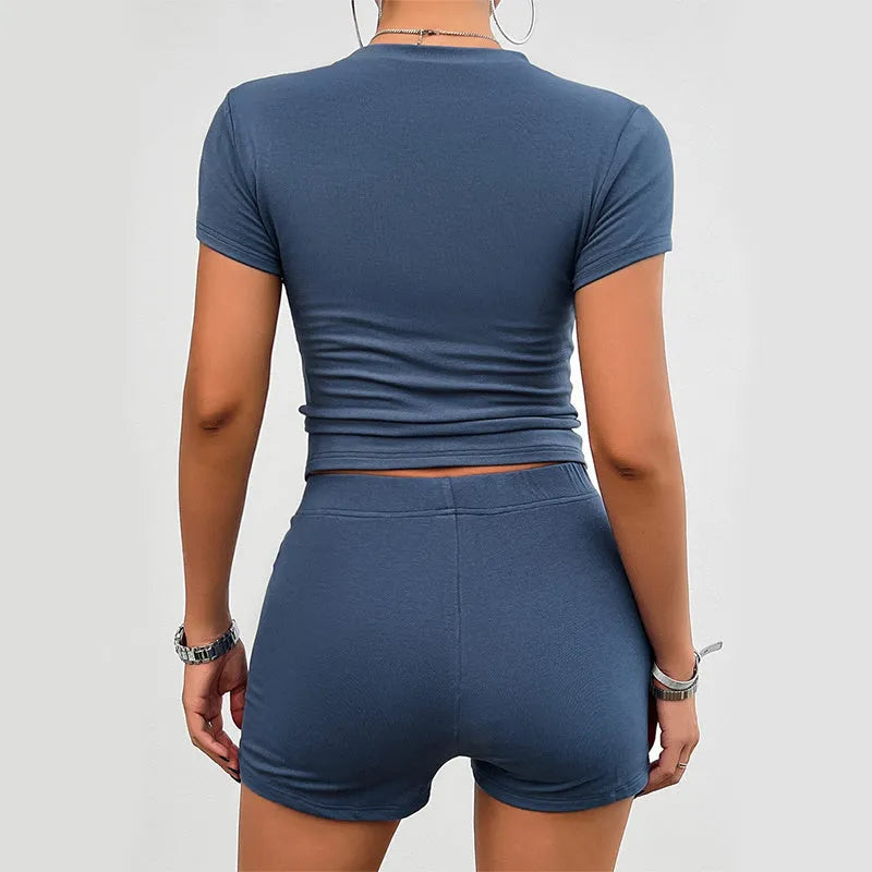 Women's solid colour slim-fit sports set with round-neck T-shirt and elastic shorts.
