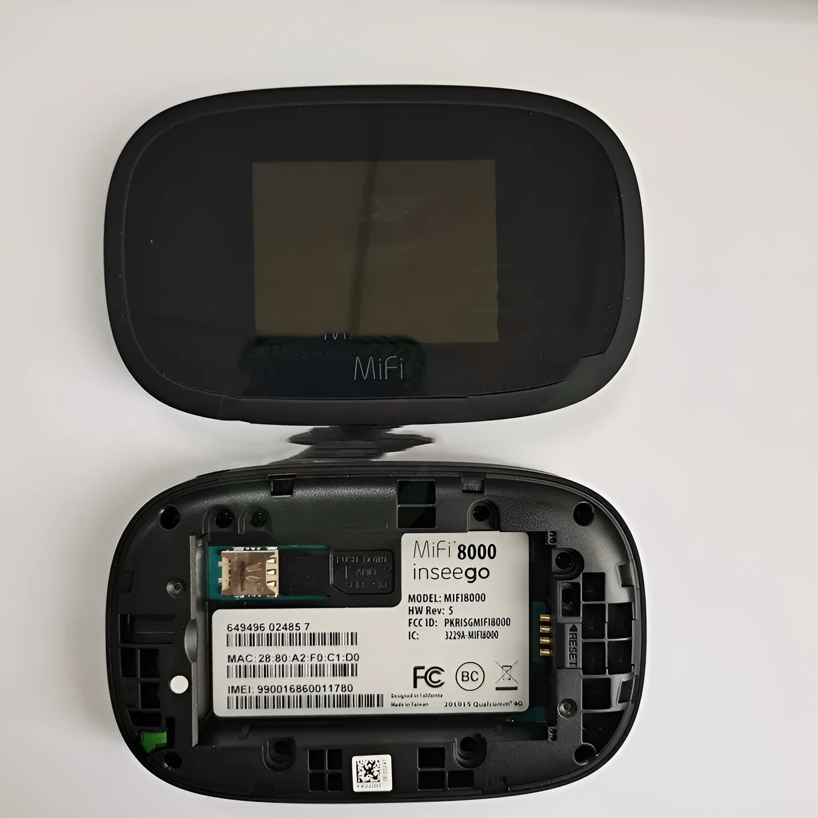 Black mifi8000 4G portable wireless router showing its compact size next to a data cable.