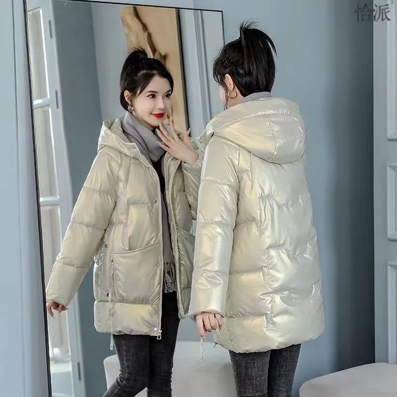 Green loose-fit hooded women's winter jacket on a hanger, showing long sleeves.