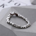 Handmade women's bracelet with silver squares and wooden beads on elastic cord