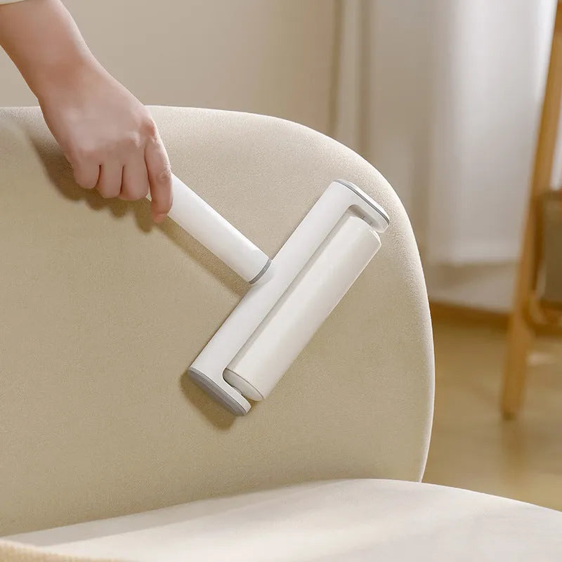 Reusable plastic lint remover roller with a long adhesive paper roll for pet hair and dust on floors.