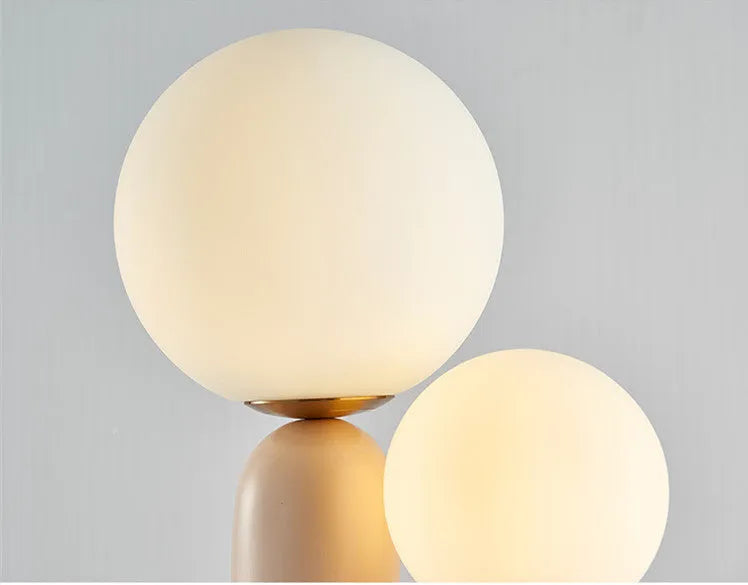 Pink double-head resin table lamp with glass shades on a bedside table, 49cm height