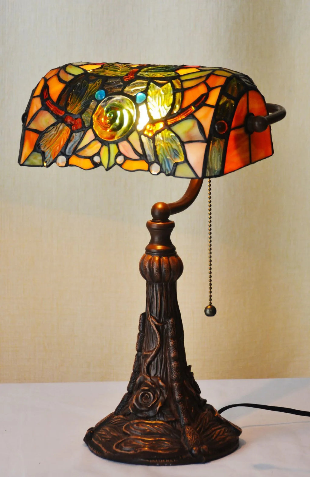 10-inch Tiffany style desk lamp with coloured stained glass shade and matching resin base on a wooden table.